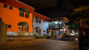 A hotel with a red facade, a balcony, and a cobblestone courtyard. - Acapú Hotel (Rio Verde)