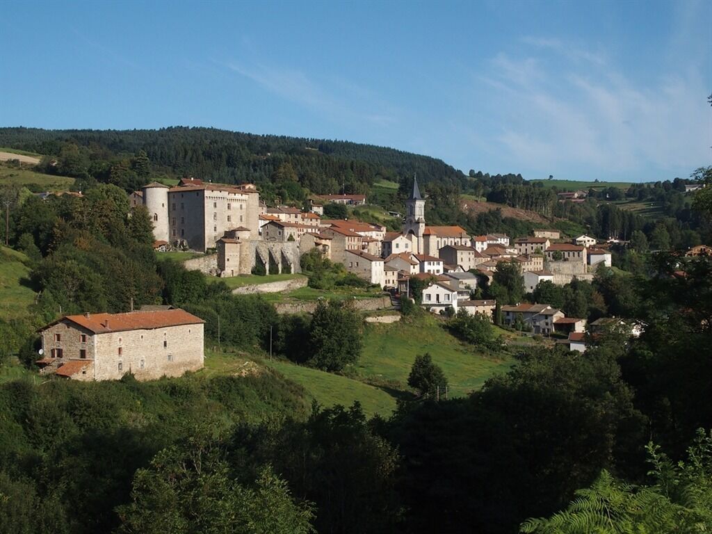 Un pueblo histórico con arquitectura medieval, que incluye una iglesia destacada y edificios similares a un castillo.