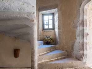 Eine enge Treppe mit einem kleinen Fenster und einem Blumentopf.