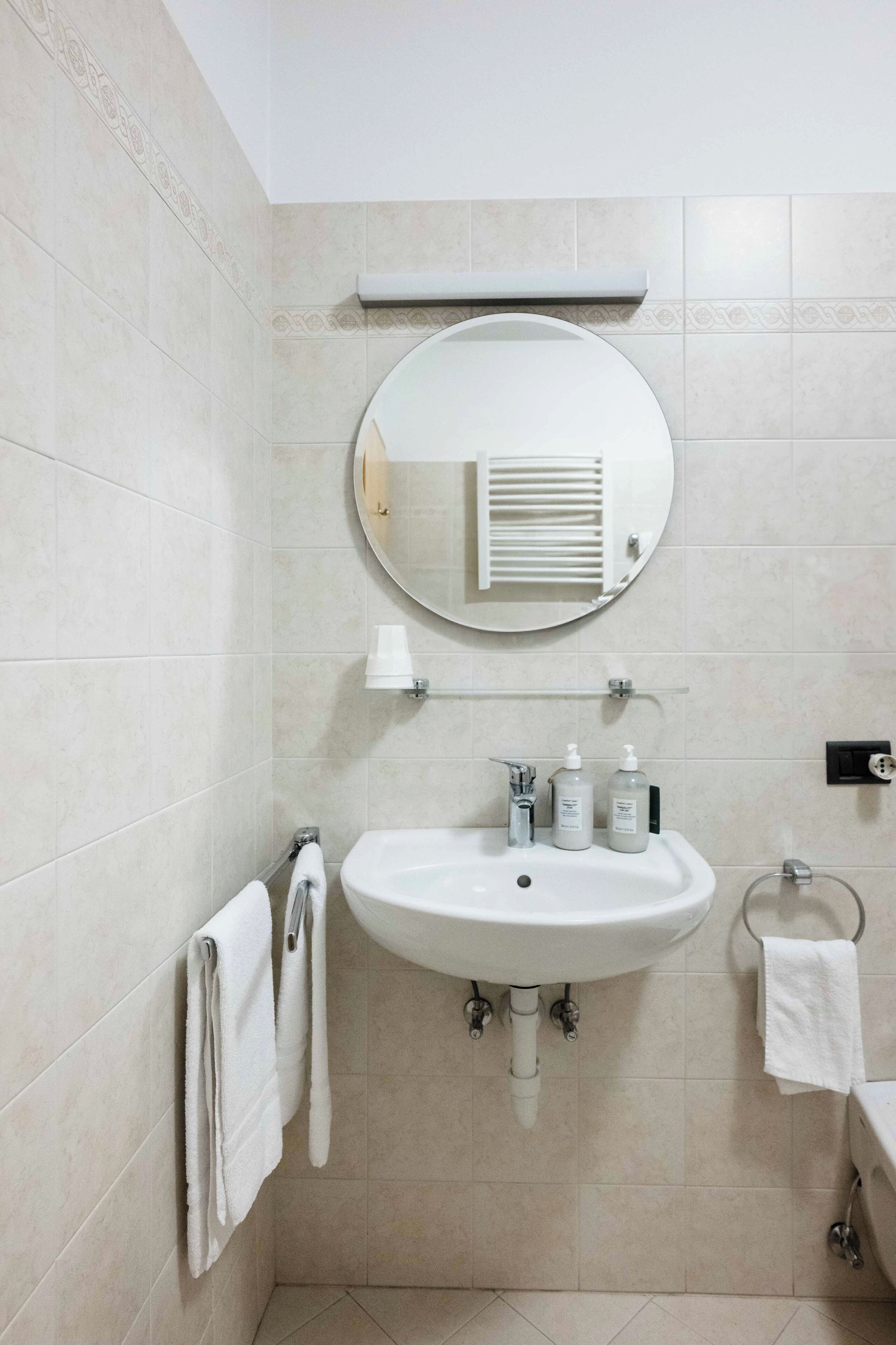 Ein modernes Badezimmer mit Waschbecken, Spiegel und Handtuchhalter.