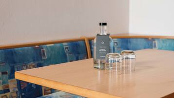 A table with a bottle of water and two glasses on it.