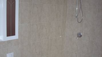 Un baño con lavabo, ducha e inodoro.
