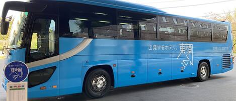 A blue bus with a sign indicating it is a hotel bus.