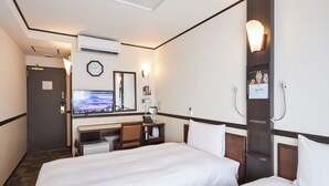 Habitación de hotel con dos camas, un escritorio con computadora, un reloj y ducha.