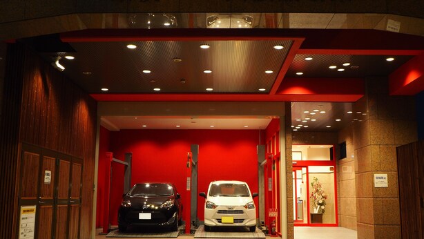 A hotel entrance with two cars parked inside. - Toyoko Inn Osaka Semba Higashi (Osaka)