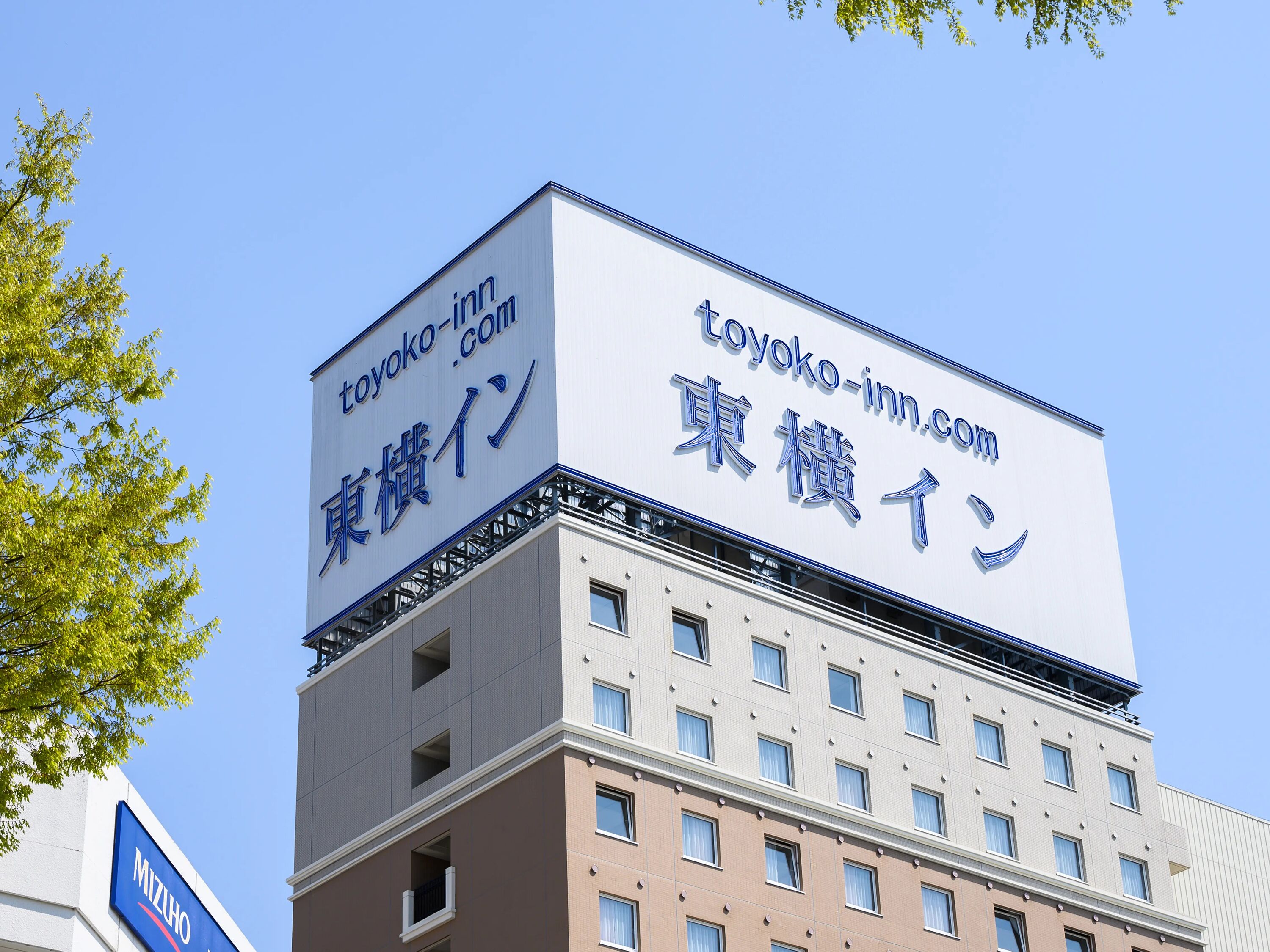 A building with a sign that reads "toyoko-inn.com" and "東横イン" in Japanese.