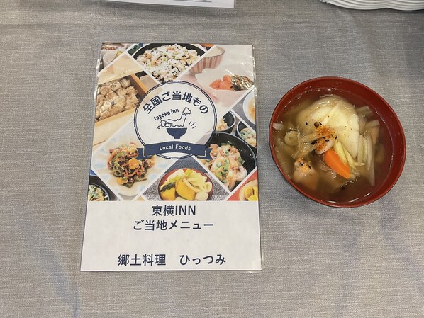 Un menu proposant divers plats et un bol de soupe aux légumes.