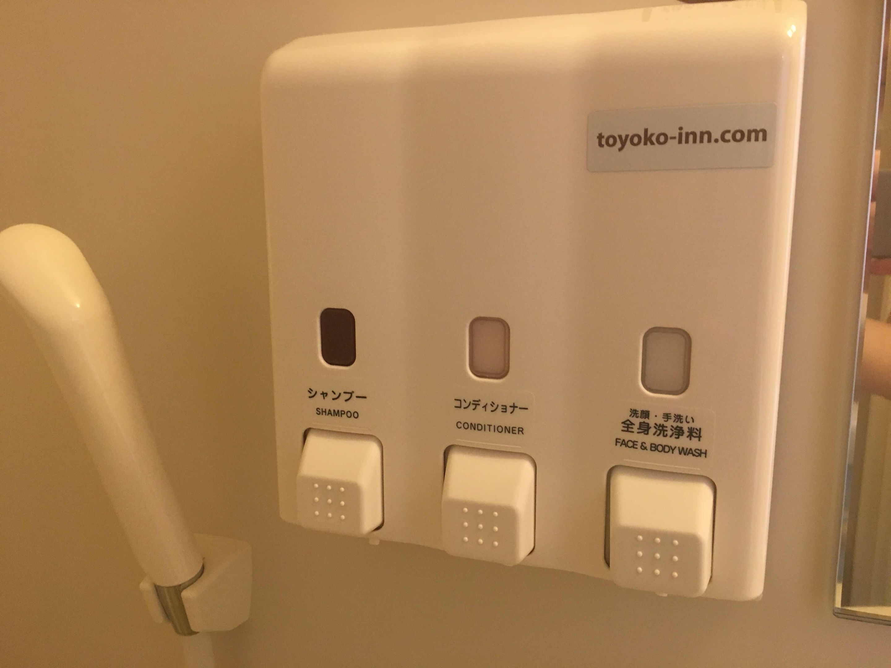 A wall-mounted control panel with buttons labeled for shampoo, conditioner, and body wash.