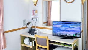 A hotel room with a desk, chair, computer, telephone, mirror, and a small refrigerator. - Toyoko Inn Shonan Hiratsuka Station Kita 1 (Hiratsuka)