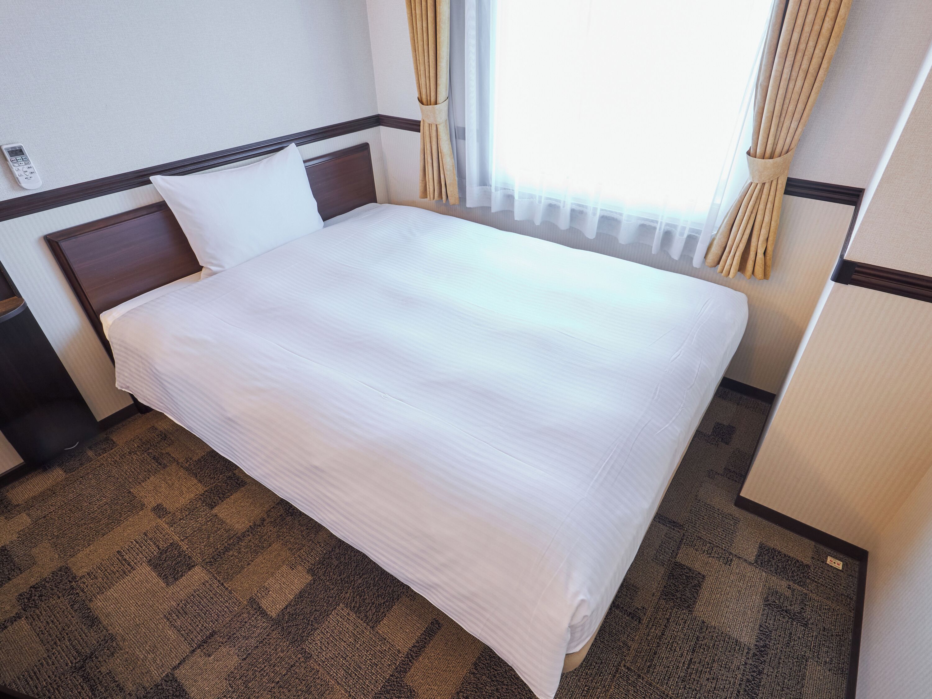 Una cama bien hecha con ropa blanca en una habitación de hotel.