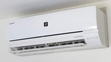 A white air conditioning unit with a control panel and a filter compartment.