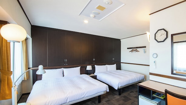 A hotel room with two beds, a desk, a chair, a small refrigerator, and a clock on the wall. - Toyoko Inn Tokyo Fussa Station Higashi (Fussa)