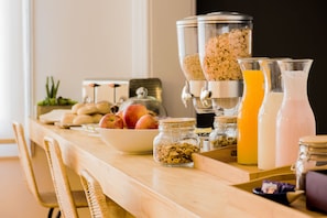 A breakfast buffet with various food items and beverages. - Casa Baquedano (Santiago)