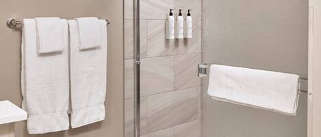A modern bathroom with a glass-enclosed shower, a toilet, and a sink.