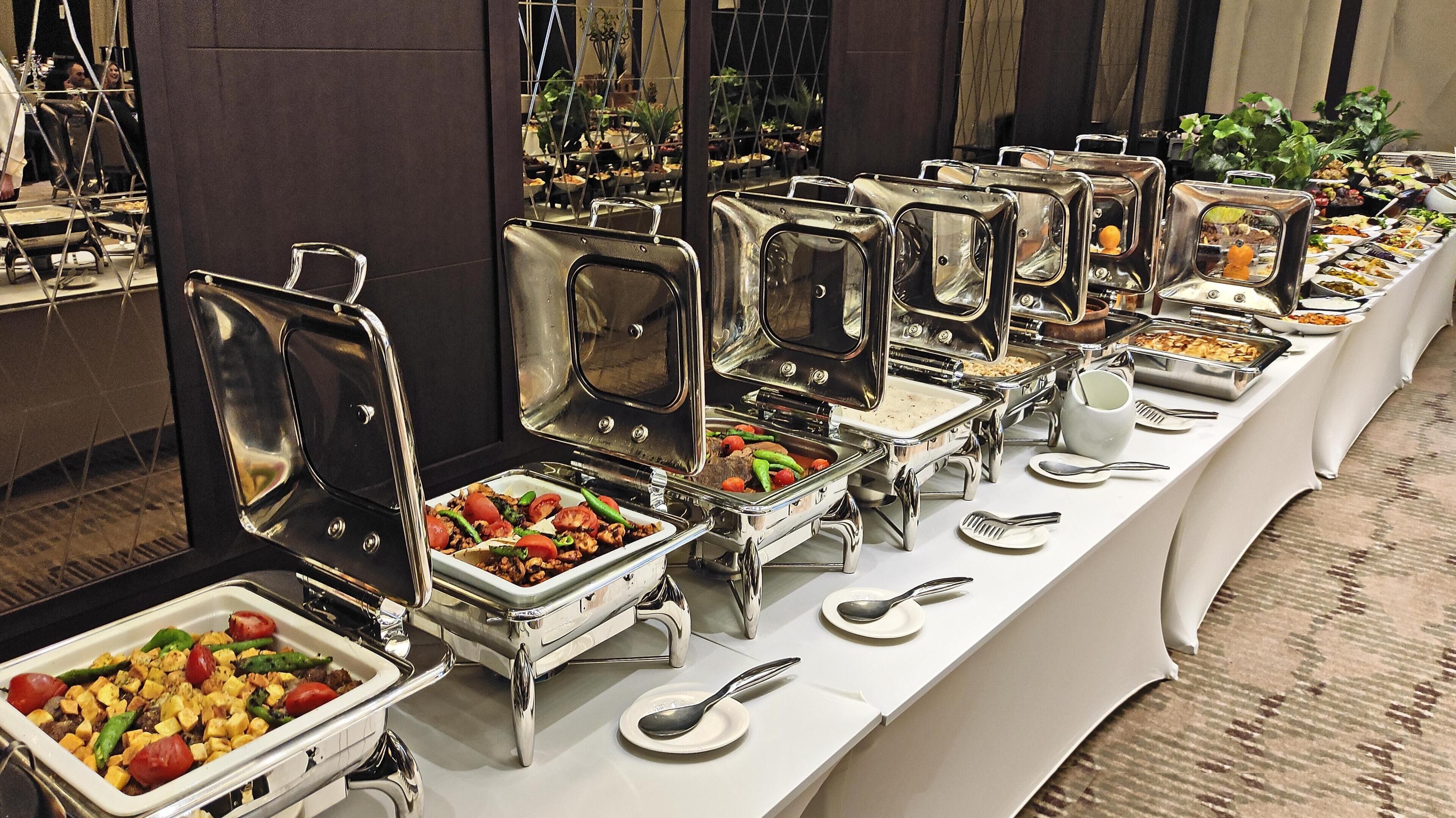 A buffet setup with multiple food stations and serving utensils.