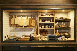 Una cocina con utensilios de madera, pan y diferentes alimentos en estantes.