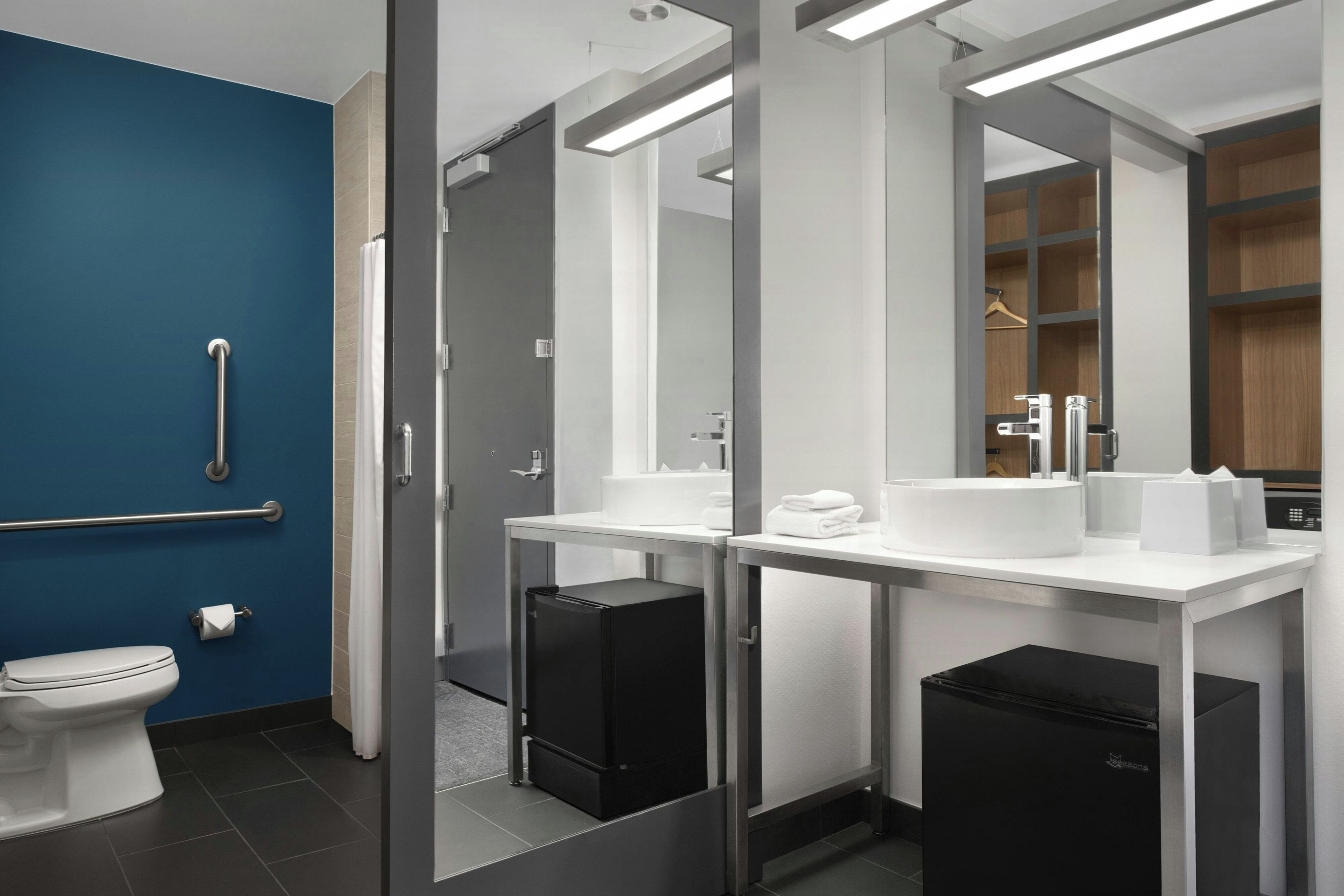 A modern bathroom with a toilet, a sink, and a mirror.