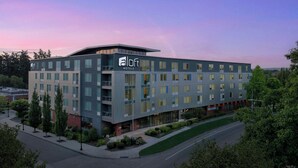 Un moderno edificio alberghiero con tetto piatto, diversi piani e un cartello ben visibile con la scritta 'Alloft Hotels'.