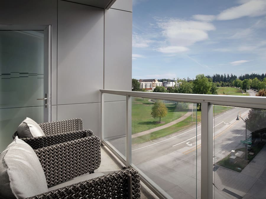 A balcony with wicker furniture and a glass door.