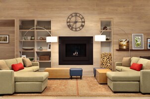 Una sala de estar moderna con chimenea, dos sofás, una mesa de centro y una estantería.