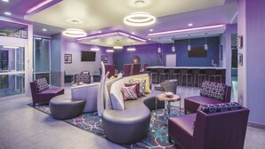 Een moderne lounge met zitplaatsen, een bar en een groot raam.
