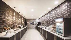 Een moderne keuken met een lange aanrecht, voorzien van diverse apparaten en een koelkast.