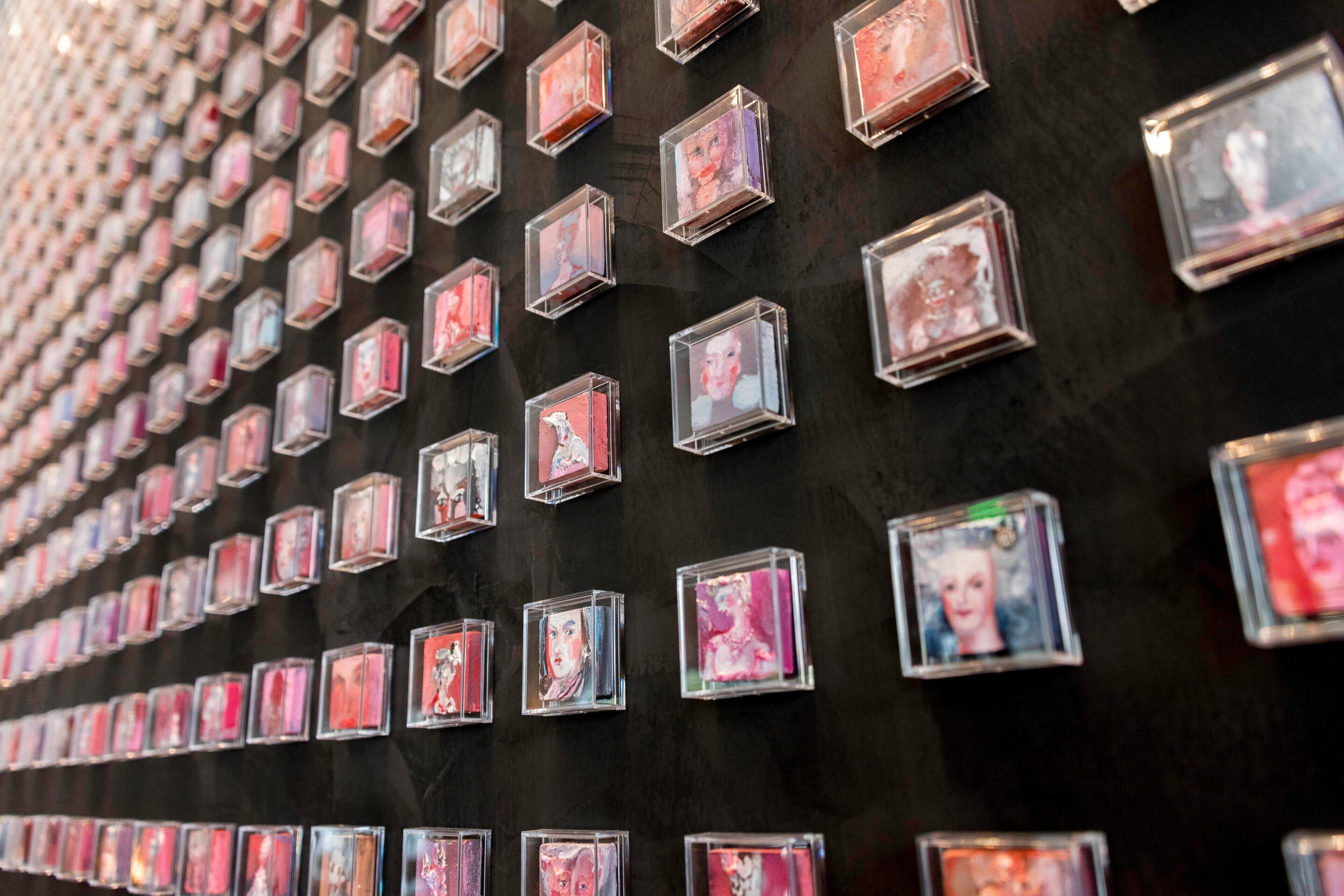 A wall with numerous square frames arranged in a grid pattern.
