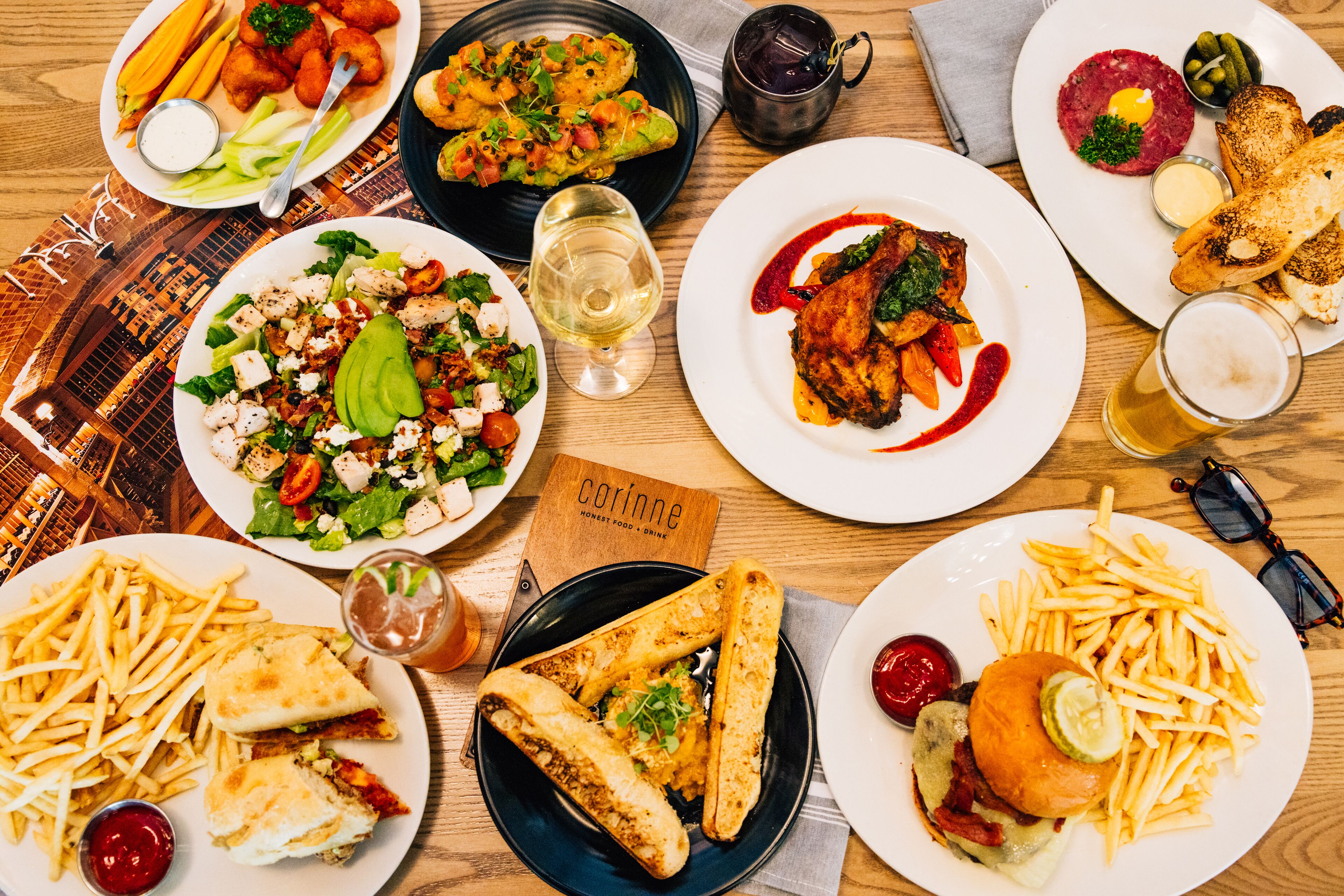 A variety of dishes and drinks on a wooden table.