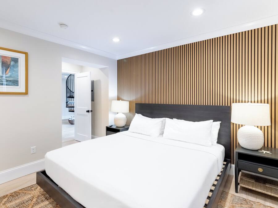 Ein modernes Hotelzimmer mit einem großen Bett, einer Wand aus Holzpaneelen und einem gerahmten Bild.