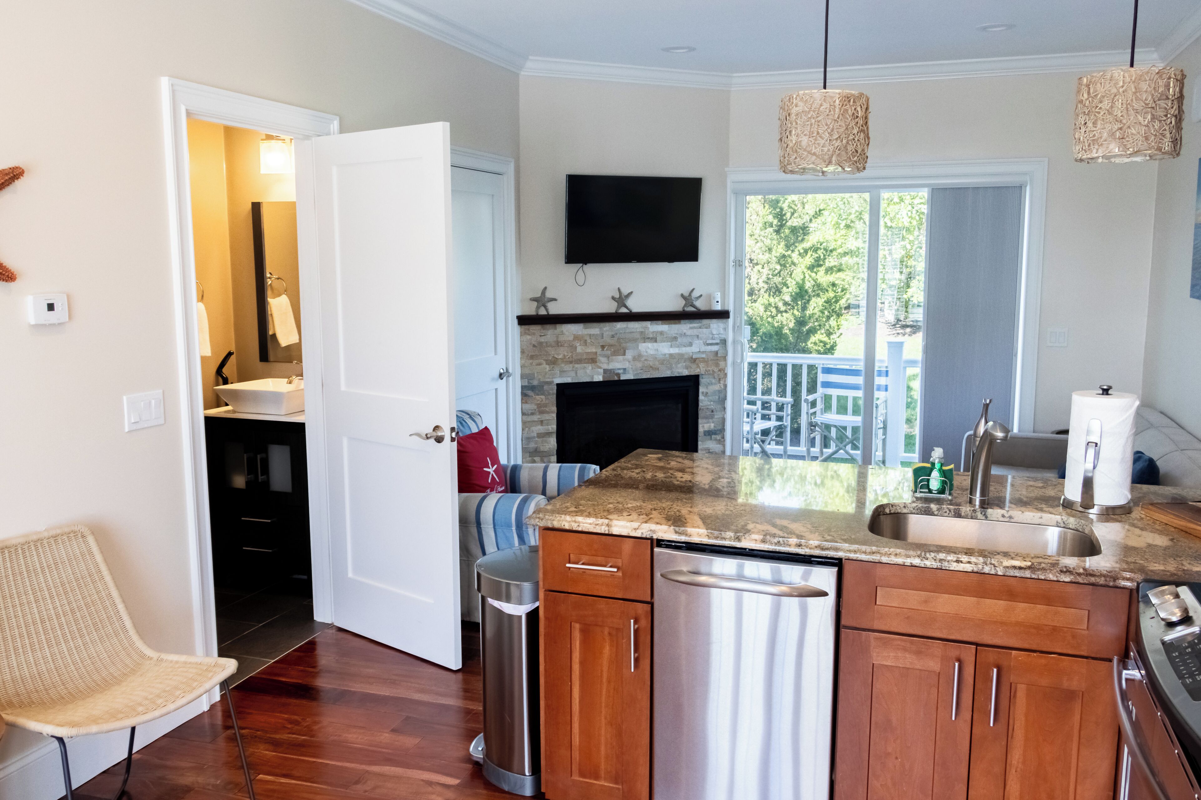 A modern kitchen with a stone backsplash, stainless steel appliances, and a large island with a sink.