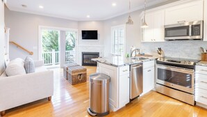 Een moderne keuken met witte kasten, roestvrijstalen apparatuur en een groot eiland.
