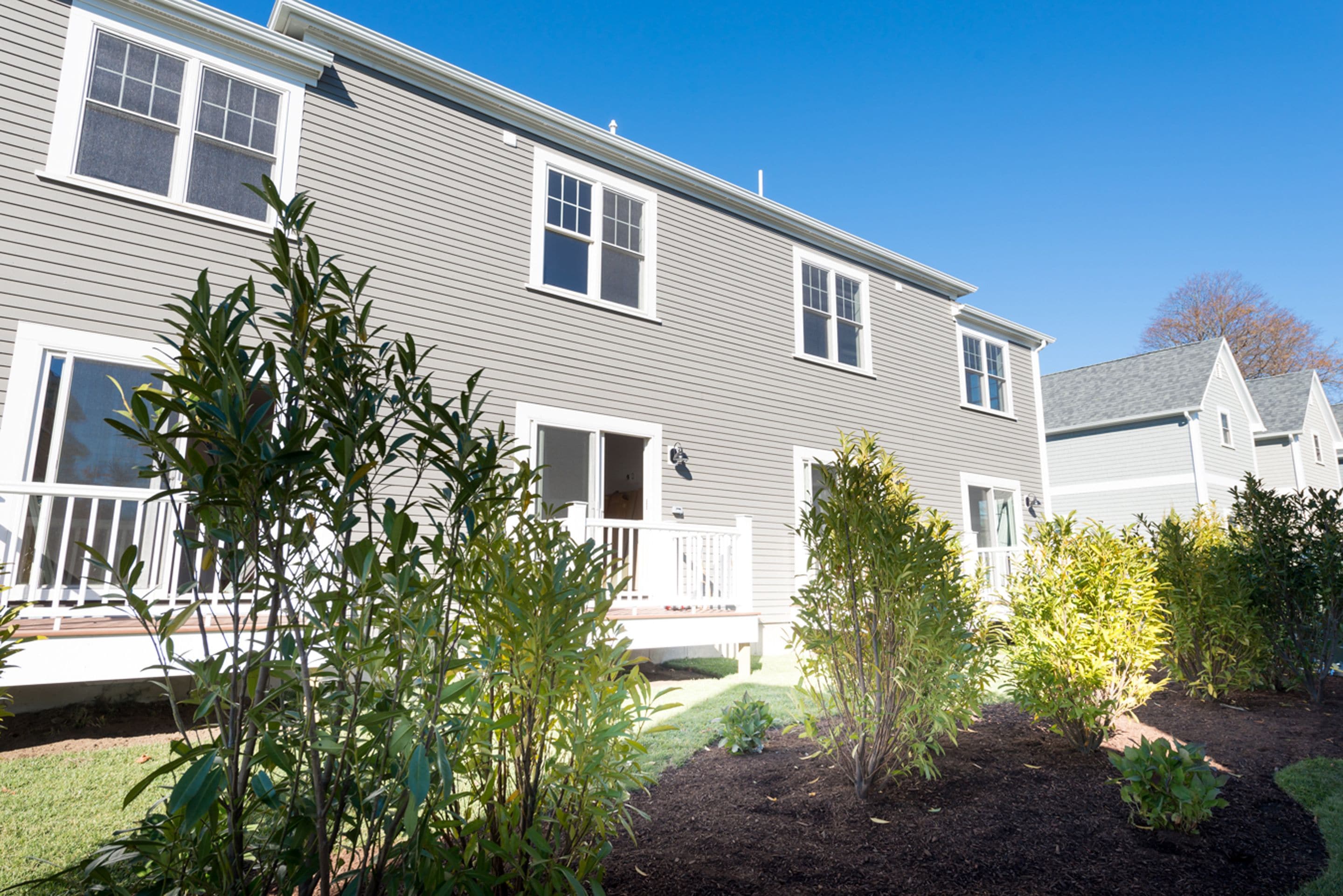 A two-story house with a front porch and a well-maintained garden.