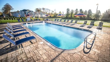 Una piscina al aire libre de temporada, sombrillas