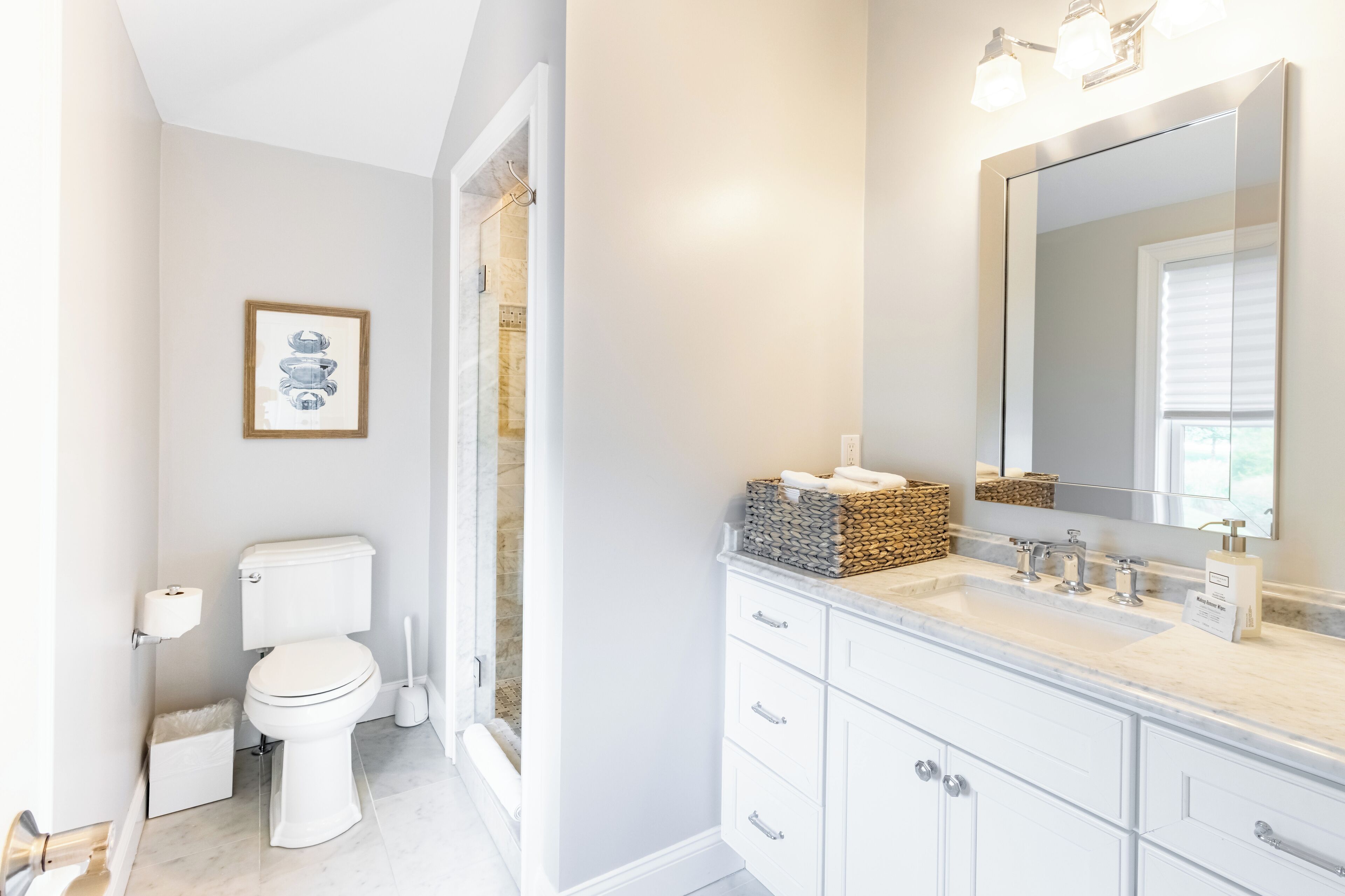 A modern bathroom with a toilet, sink, and vanity.