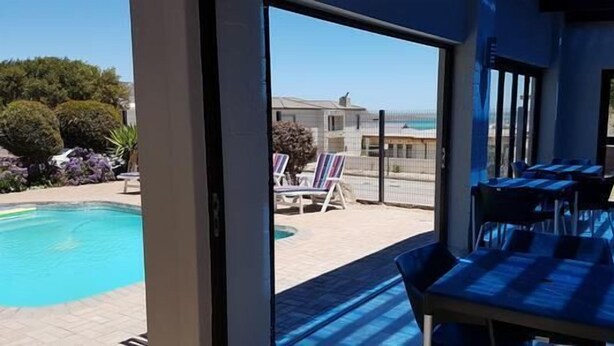 A poolside area with a view of the pool and a building in the background.