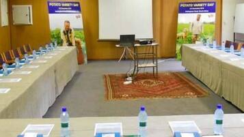 A conference room with long tables, chairs, and water bottles.