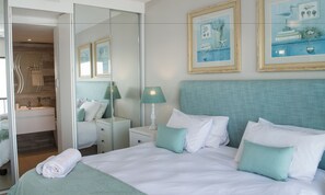 Relax in a stylish room with a large bed, bedside table, and framed artwork.