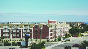 A multi-story building with a red facade, large windows, and a flat roof.