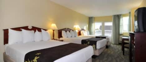 Une chambre d’hôtel avec deux lits, un bureau et une télévision.