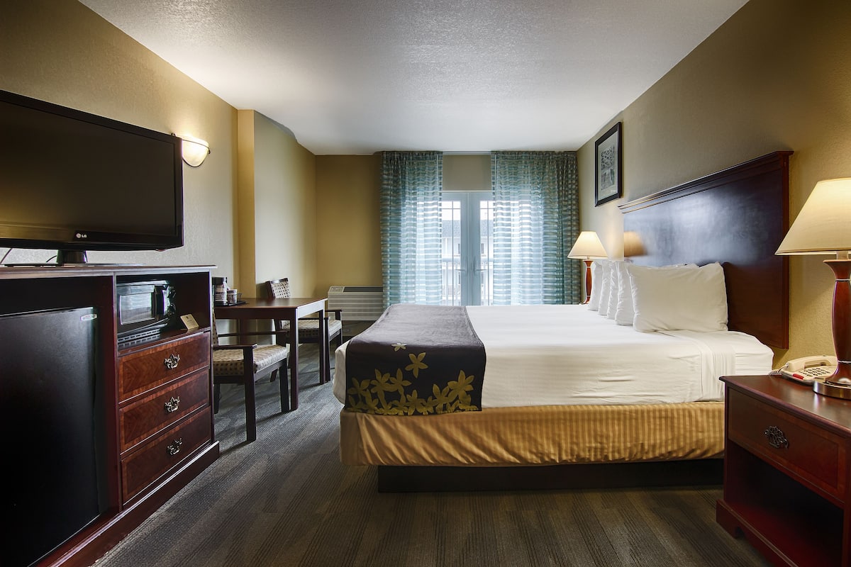Een hotelkamer met een bed, een bureau, een televisie en een telefoon.