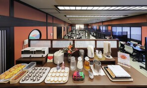 A buffet setup with various food items and a coffee station in a hotel dining area. - Omiya Ryokan (Yamagata)