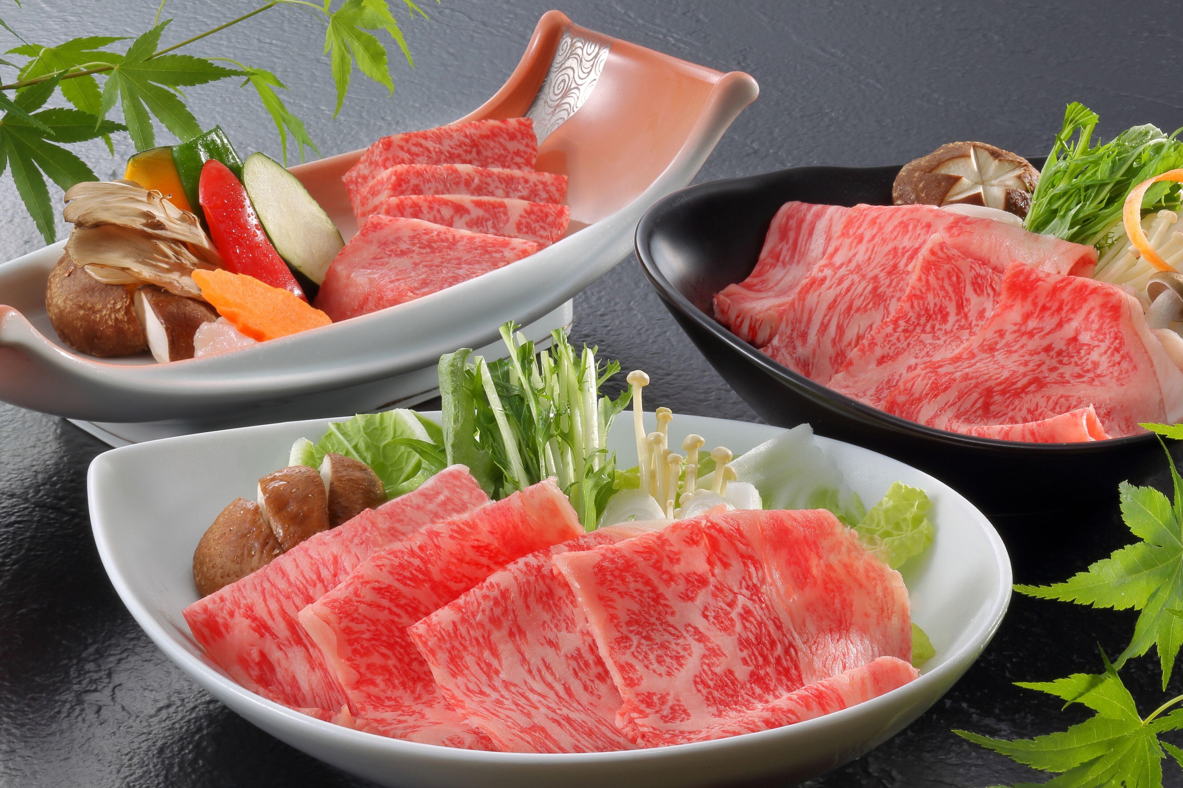 A variety of food items including sliced watermelon, vegetables, and meat arranged on plates.