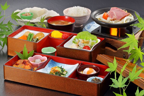 Una comida tradicional japonesa con diversos platos y un recipiente caliente.