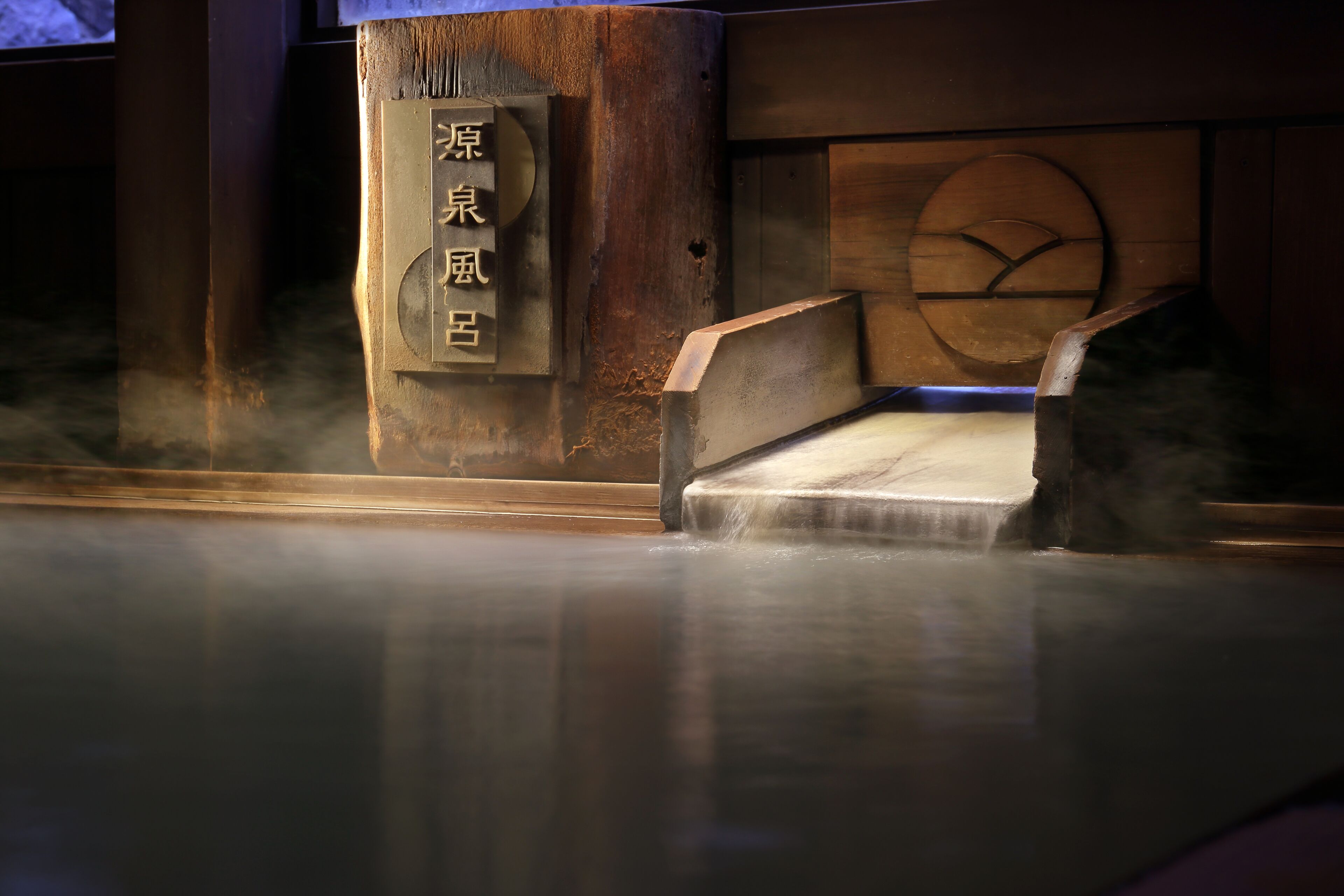 A traditional Japanese architectural feature with a wooden structure and a stone base, possibly part of a historical building or temple.