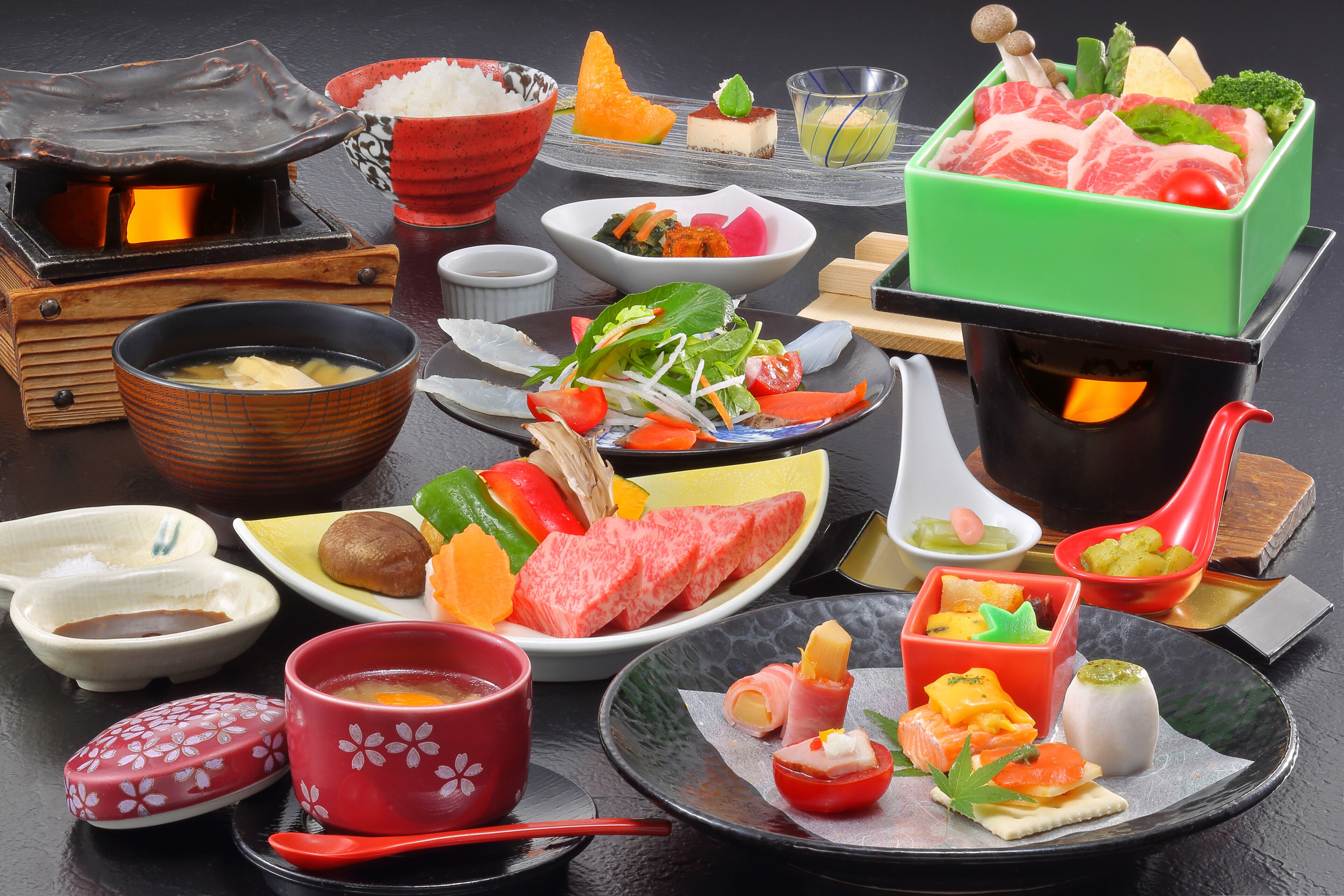 A variety of Japanese dishes, including sushi and sashimi, served on different plates and bowls.