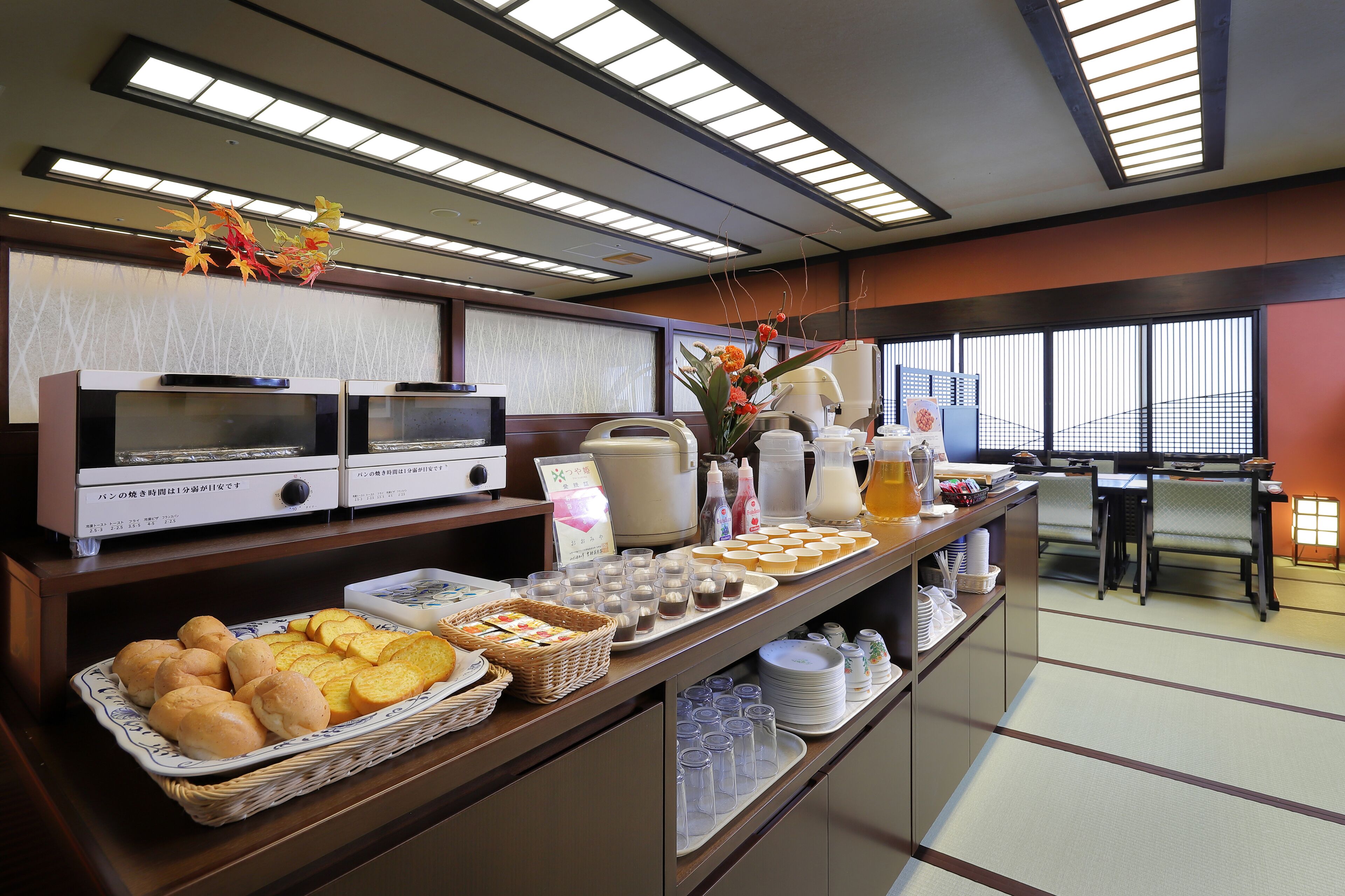 A buffet area with various food items, a coffee station, and a seating area with tables and chairs.