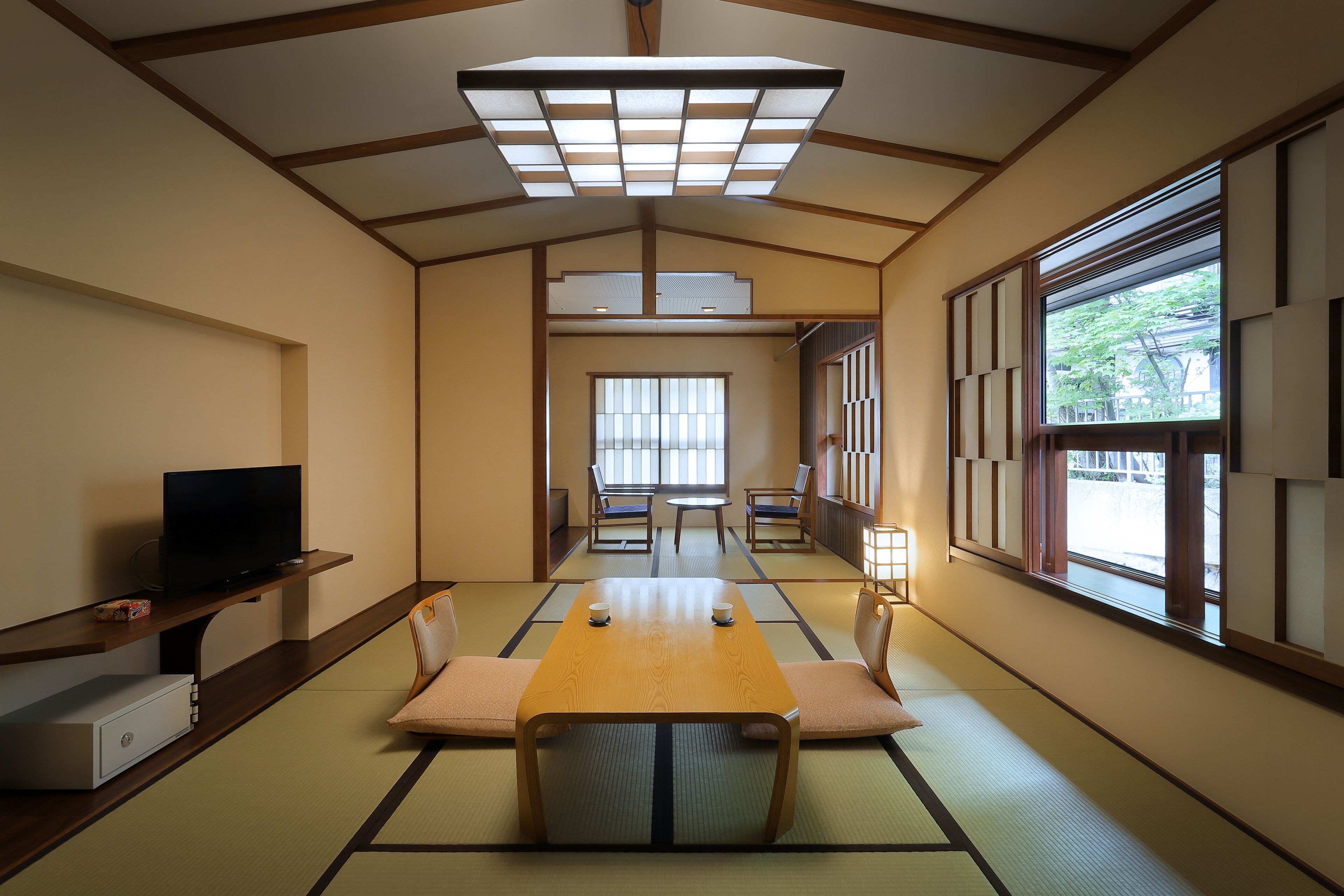 A traditional Japanese-style room with tatami flooring, a low table, and shoji screens.