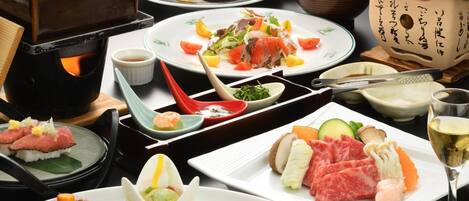 A variety of Japanese dishes including sushi, sashimi, and tempura, served on traditional ceramic plates and bowls.