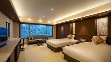 A modern hotel room with two beds, a sofa, a TV, and large windows with a snowy view.