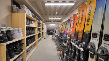Una tienda de equipo de esquí con estantes llenos de esquíes y botas de esquí.